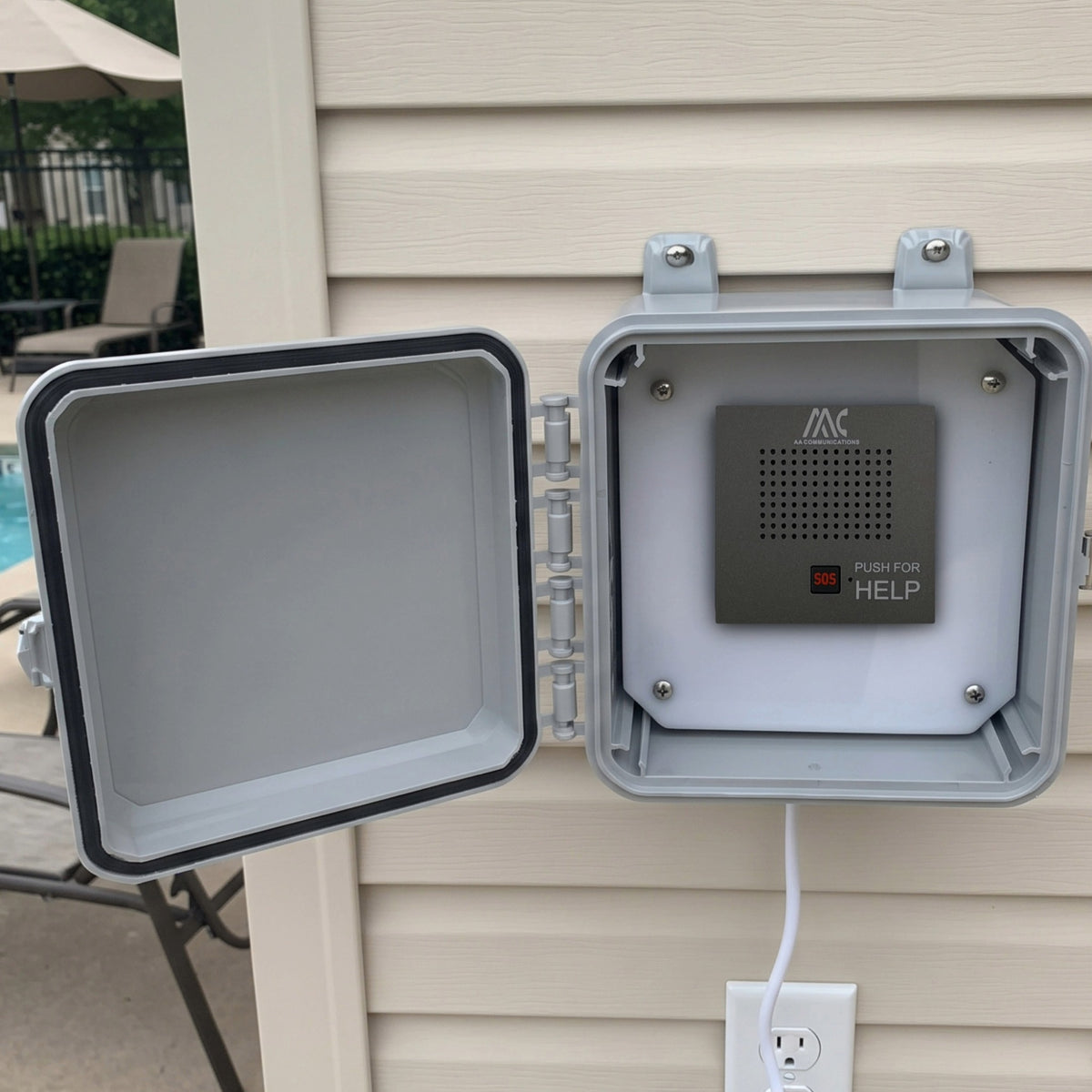 Outdoor emergency pool phone call box open and mounted on exterior siding near pool deck